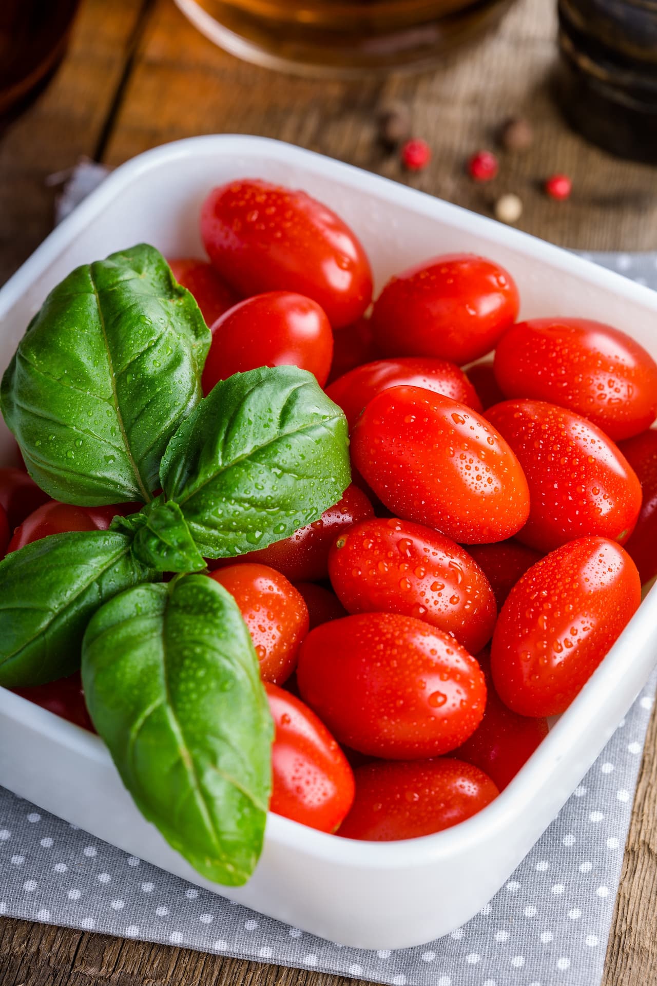 Sprig of basil in dish with grape tomatoes